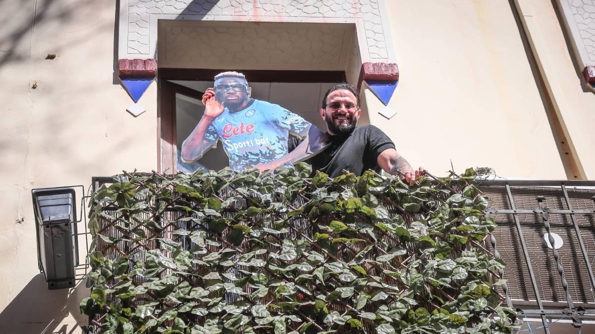 Giuliano posa en el balcón del Spots Bar con una figura de Osimhen