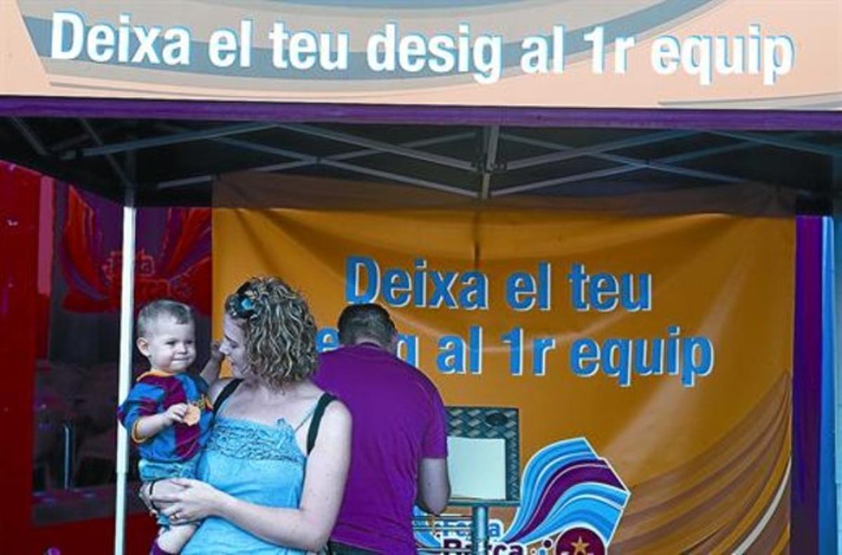 Una aficionada del Barça, amb el seu fill, després de dipositar un desig per al primer equip a les instal·lacions del Camp Nou.