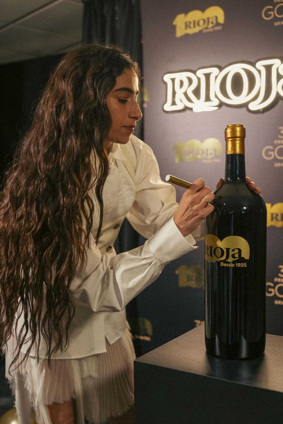 La actriz Carolina Yuste firma una botella de vino el pasado sábado en Granada