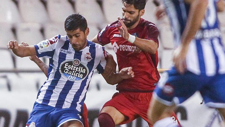 Juanfran le disputa un balón a Ángel Lafita