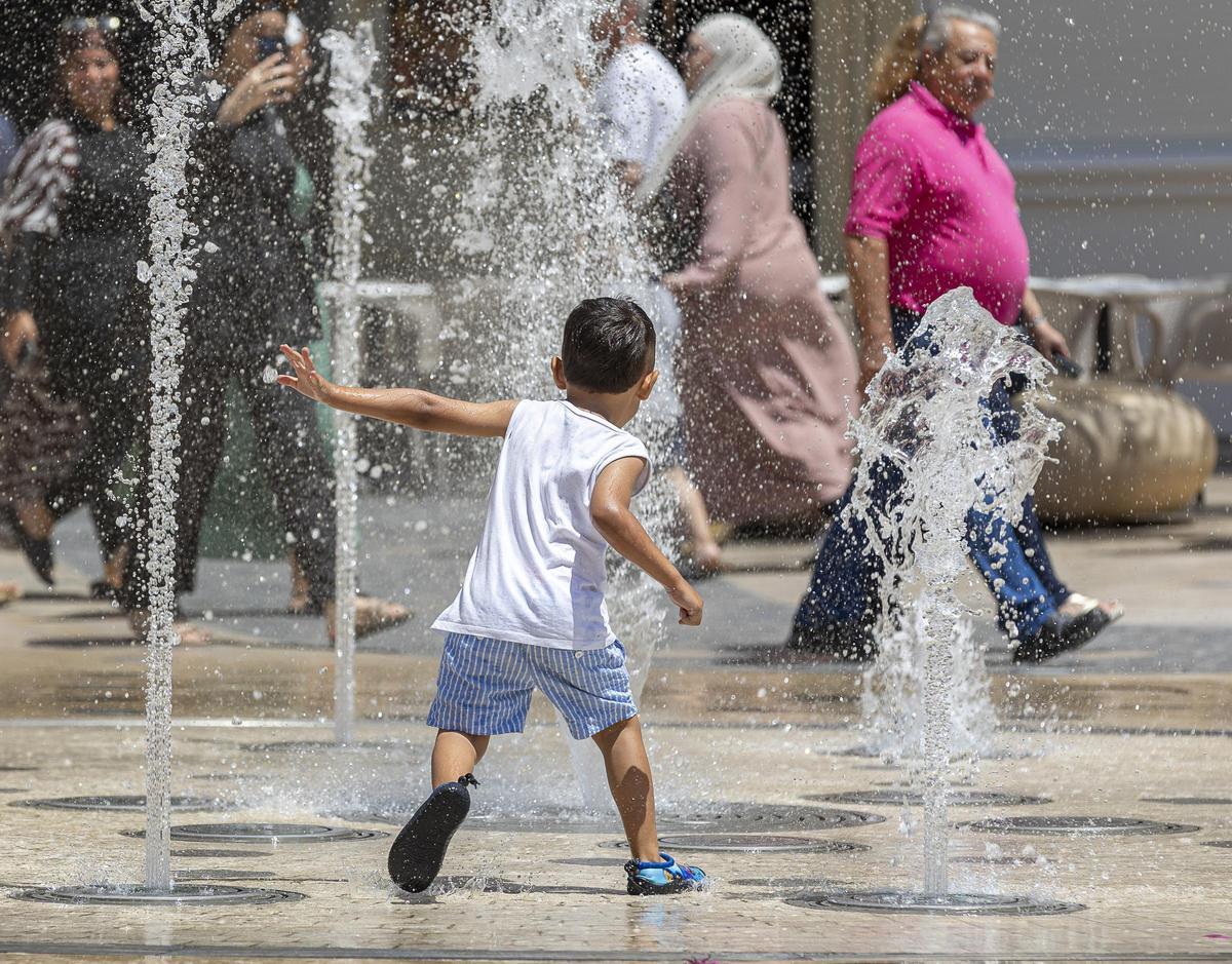 Un niño se refresca en Alicante ante las altas temperaturas