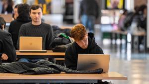 Varios alumnos de la UAB, repasando apuntes en sus ordenadores antes de ir a clase.