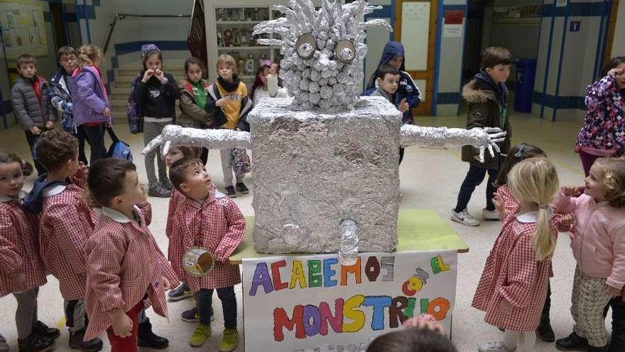 Alumnos del colegio El Quirinal rodean la figura de papel de aluminio hecha con envoltorios de los bocadillos.