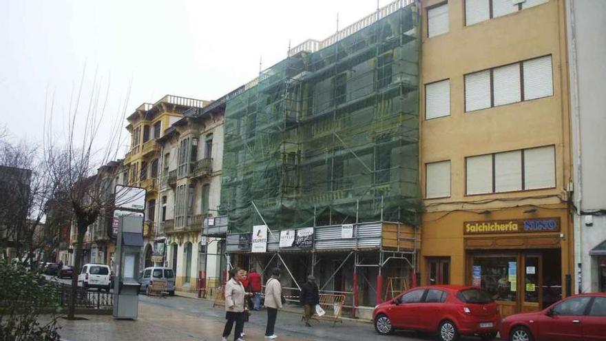 Vecinos pasean por la plaza de Santa Marina y, al fondo, un edificio en obras. Foto