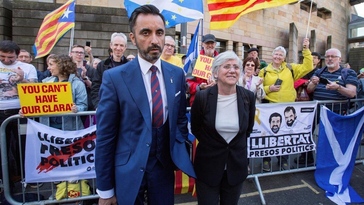 Clara Ponsatí acompañada de su abogado, Aamer Anwar, posa ante varias personas que la apoyan con pancartas  a su salida del tribunal de Edimburgo.