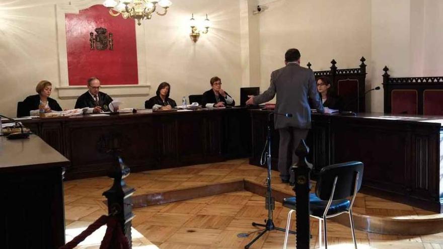 El imputado se aproxima a la fiscal para escuchar el interrogatorio porque padece sordera.