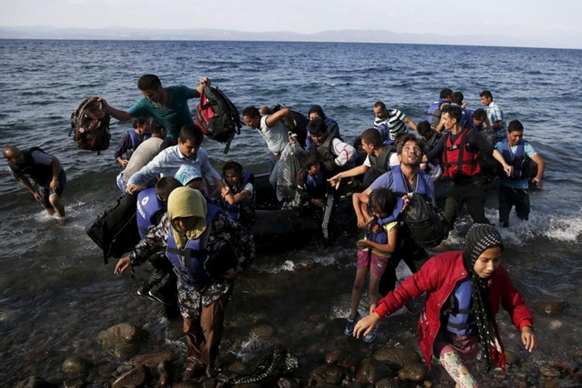 Un grupo de inmigrantes afganos toman tierra en la isla griega de Lesbos tras una travesía por mar desde Turquía.