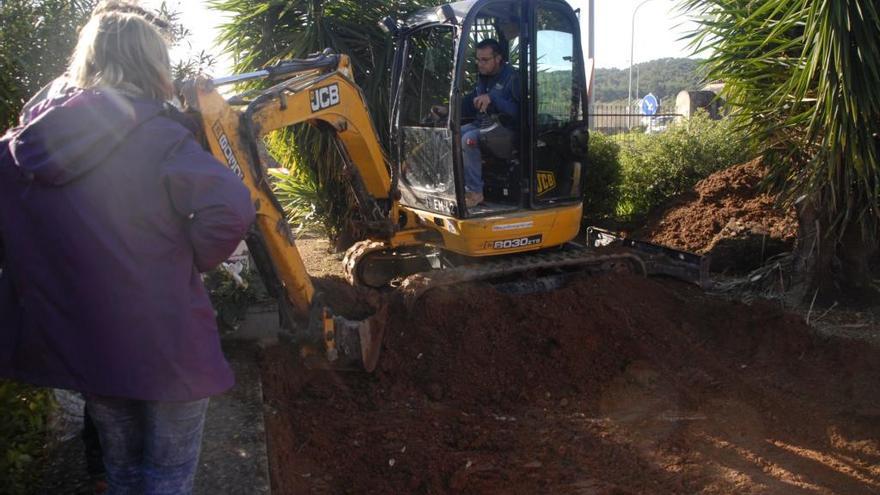 La máquina excavadora retirando tierra de la fosa común