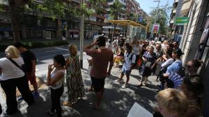 Cola para tomar un bus en la ruta del Park Güell, en Barcelona.