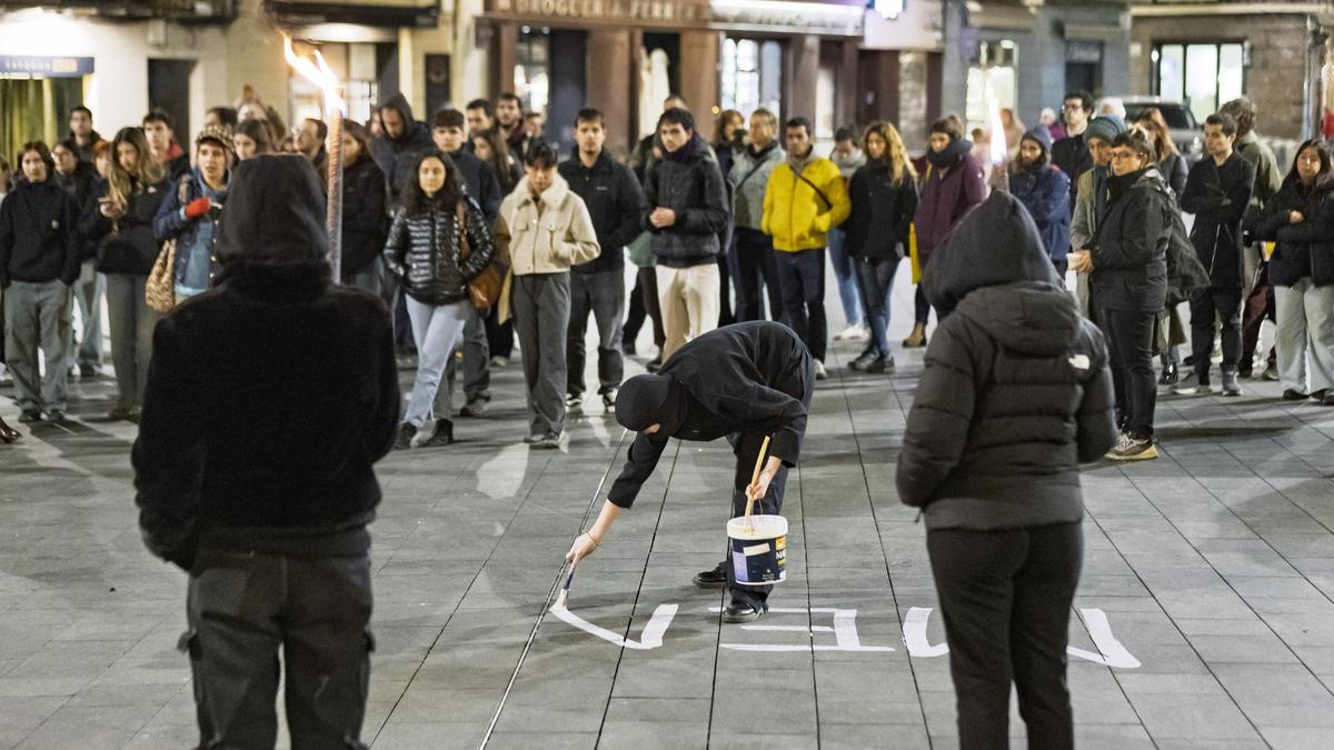 Un moment de la pintada del lema de la vetllada a la plaça Major de Manresa