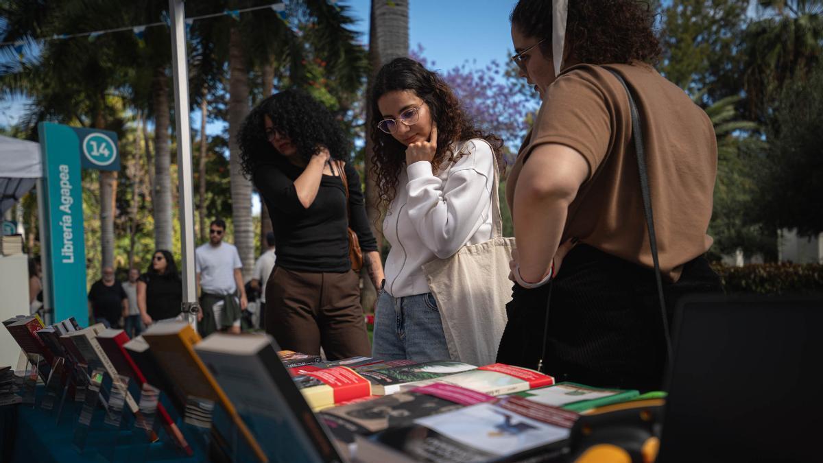 Varias visitantes miran las novedades literarias de uno de los puestos de la Feria del Libro.