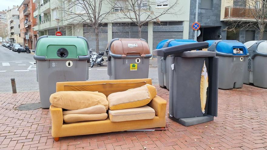 Dos sofàs vells al costat d’uns contenidors a Girona.  | DDG