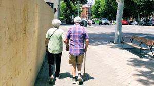 Dos personas mayores, paseando de la mano por Madrid.