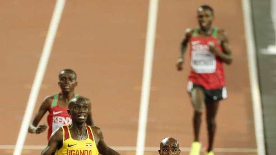 Farah levanta los brazos al cruzar la línea de meta. // Reuters