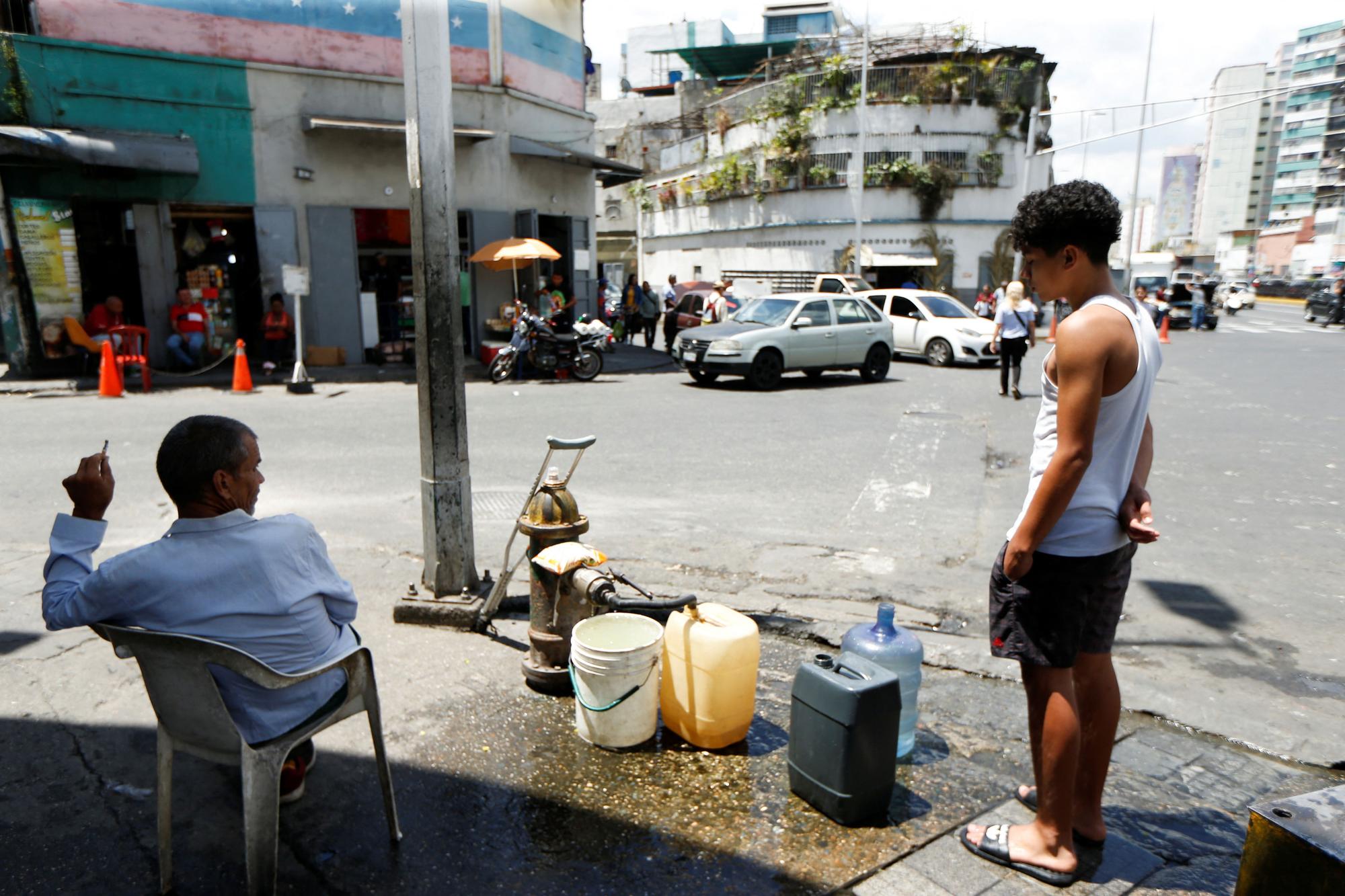 People get water from a fire hydrant, in Caracas