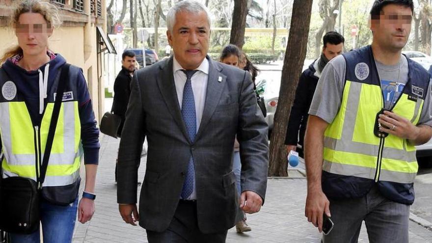 El presidente de Ausbanc, Luis Pineda, flanqueado por dos agentes de policía tras el registro de la sede.