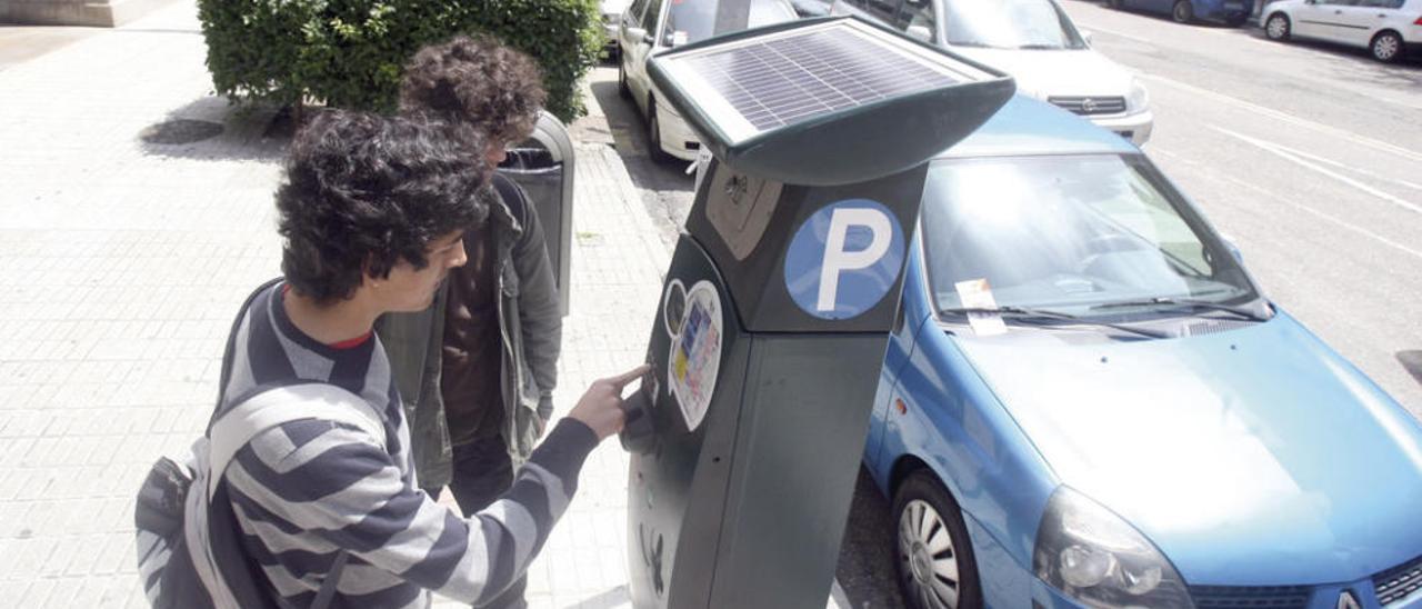 Usuarios de la zona azul pagando en uno de los parquímetros de Rosalía de Castro. // FDV