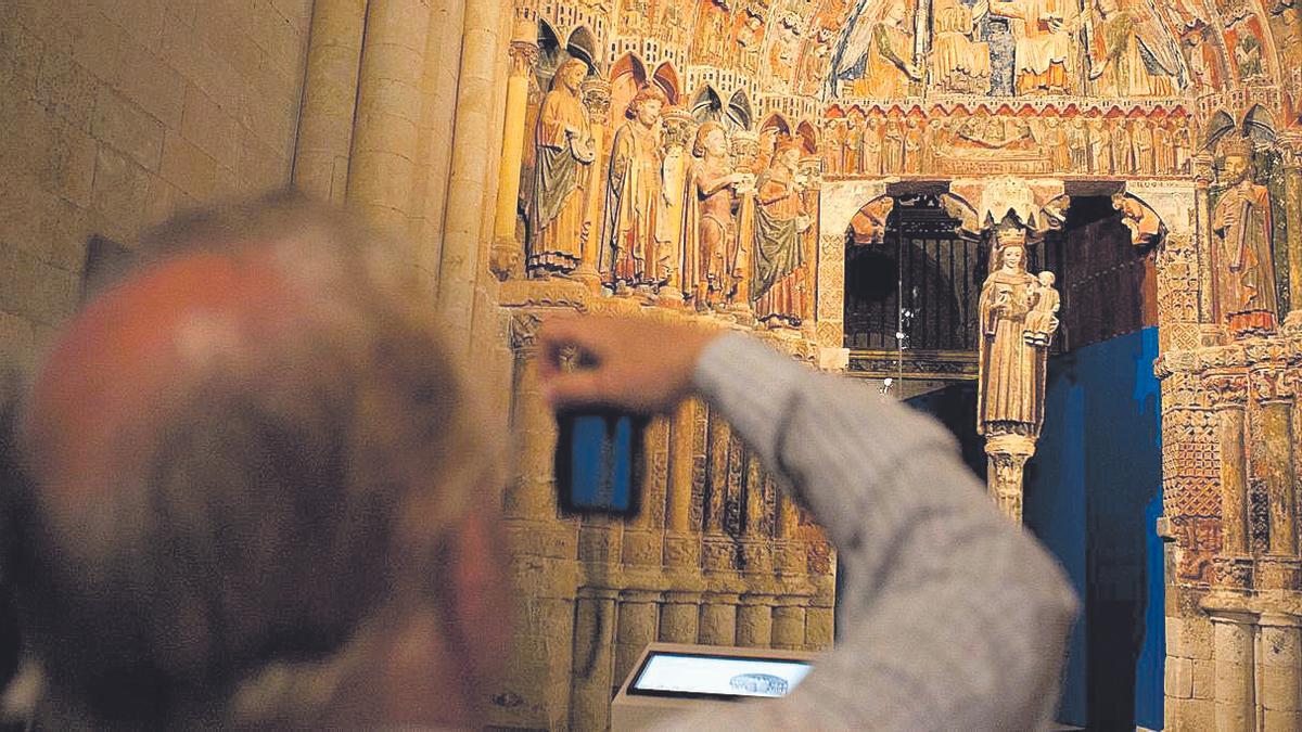 Un turista fotografía la Puerta de la Majestad en la Colegiata de Toro