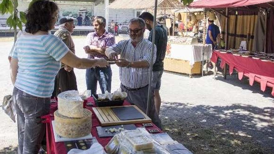 Un puesto de queso asturiano ofrece cata a un cliente. // Bernabé/A.A.