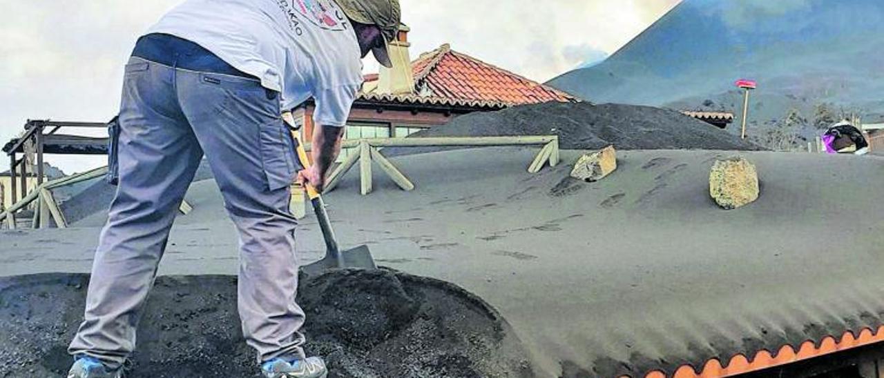 Cuadrilla de voluntarios, organizadas por la asociación vasca Galdakaoko, trabajando en la retirada de cenizas de varios tejados y caminos en una zona muy próxima al volcán.