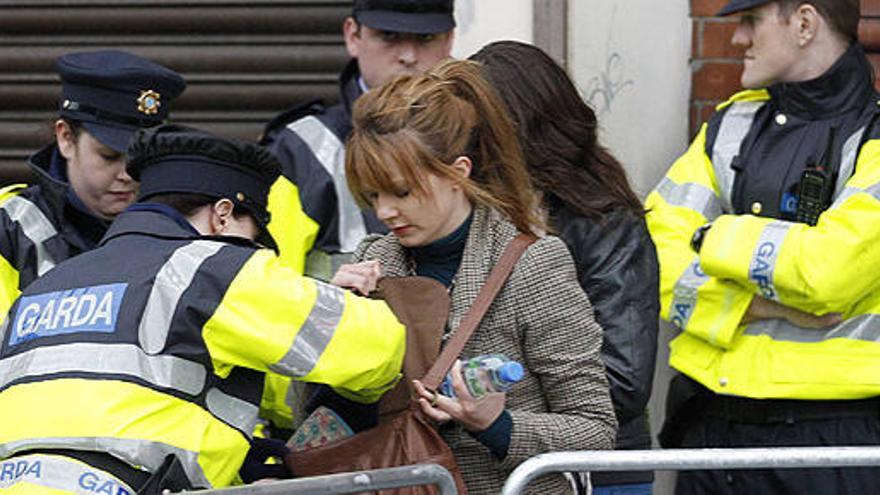 Policías irlandeses registran el bolso de una mujer en Dublín, este lunes