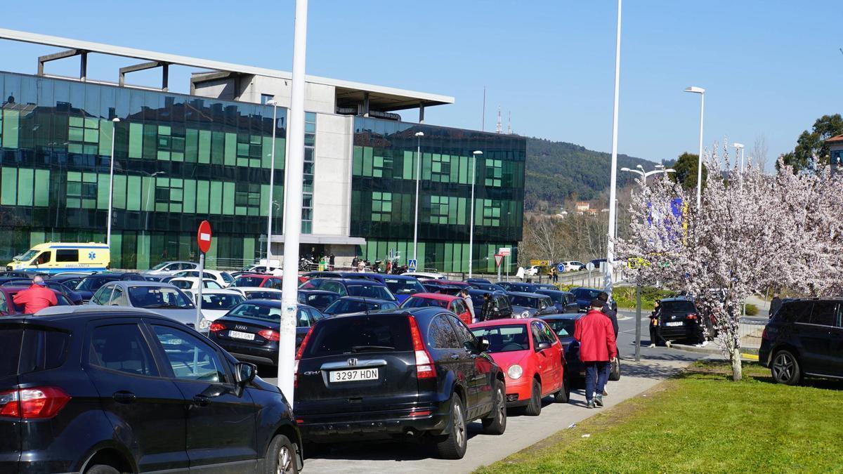 Coches aparcados encima de la acera en el Hospital Clínico de Santiago.