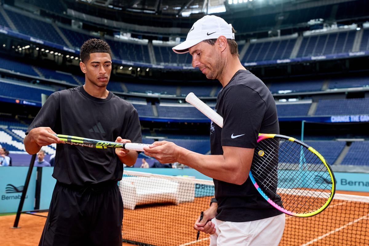 El extenista Rafael Nadal (d) y el futbolista Jude Bellingham, en la pista de tenis del estadio Santiago Bernabéu.