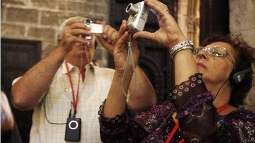 Dos turistas hacen fotos dentro de la catedral de Valencia el domingo pasado.