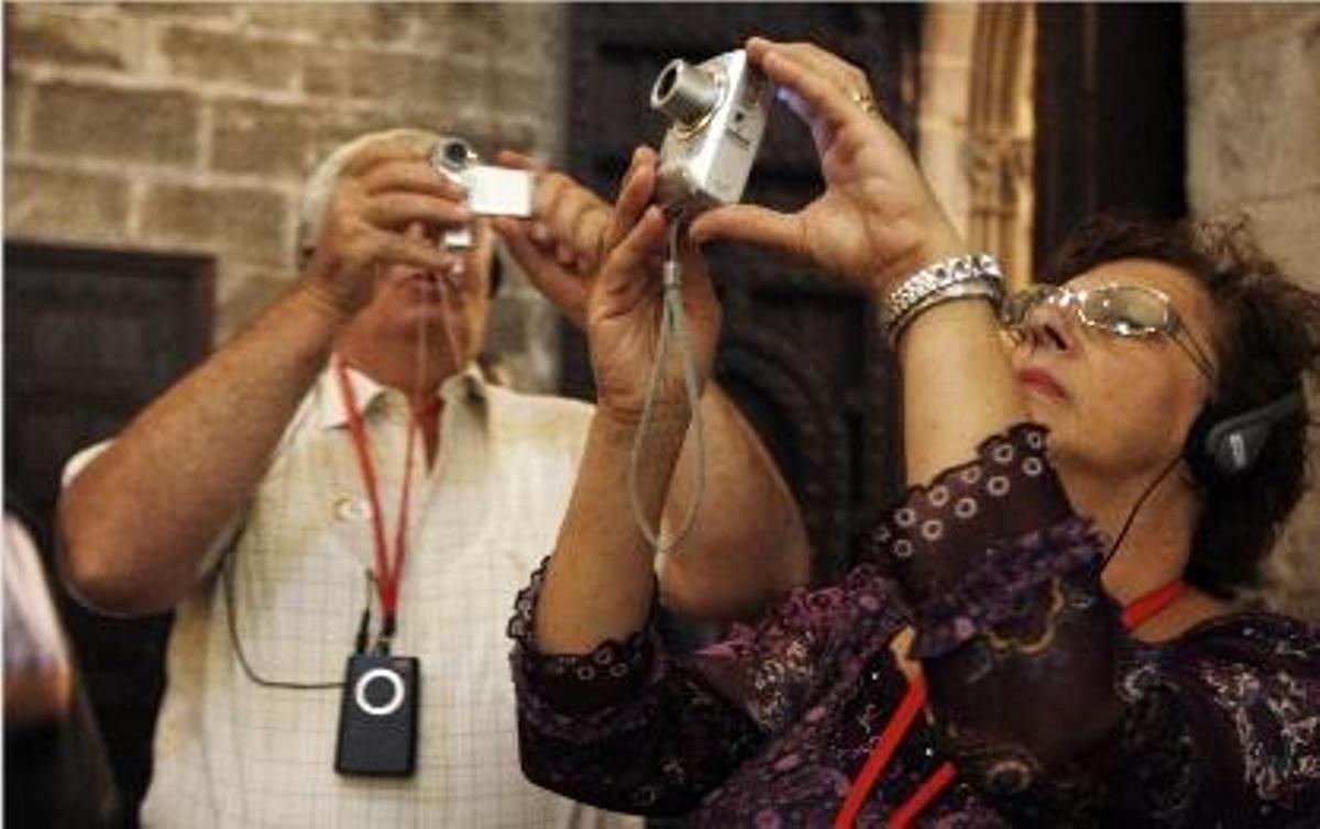 Dos turistas hacen fotos dentro de la catedral de Valencia el domingo pasado.