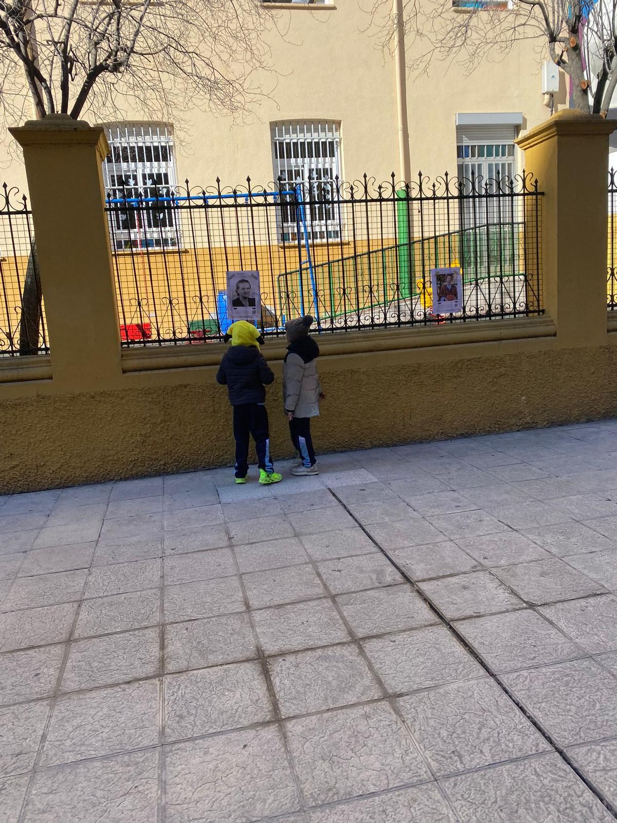 Dos niños observan uno de los carteles.