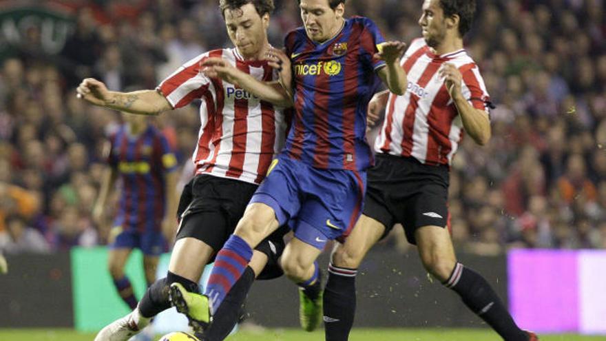 Messi intenta escaparse de dos defensa en La Catedral.