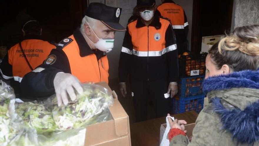 Voluntarios de Protección Civil reparten alimentos a los usuarios del comedor San Francisco. // R. Vázquez