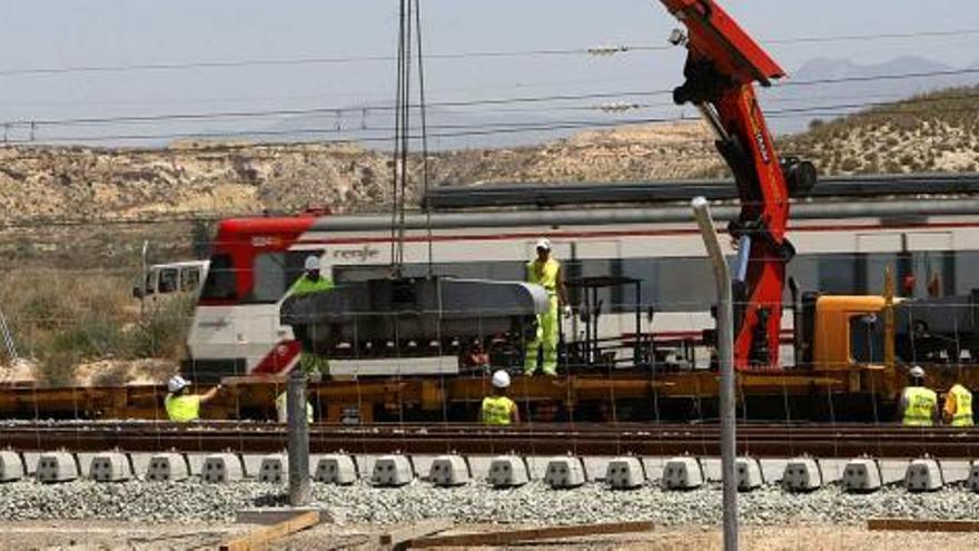 Un tren de cercanías de la línea Alicante-Murcia pasa junto a la zona donde se desarrollan los trabajos de acceso del AVE .