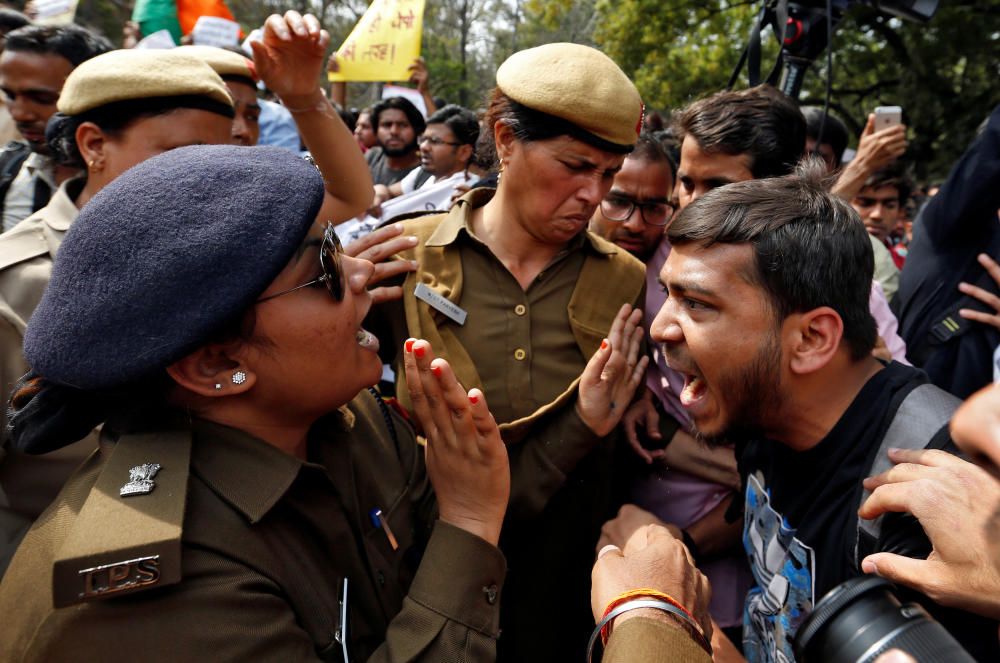 Un manifestante se enfrenta a la policía durante una marcha contra la violencia y la intimidación en la Universidad de Nueva Delhi, en India.