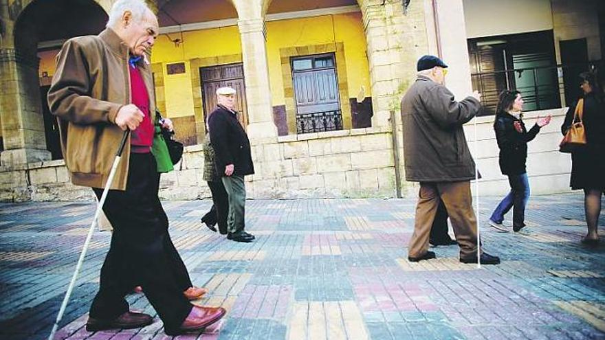 Los invidentes que ayer participaron en la primera visita guiada para ciegos por el casco histórico de Avilés, en la calle La Ferrería.