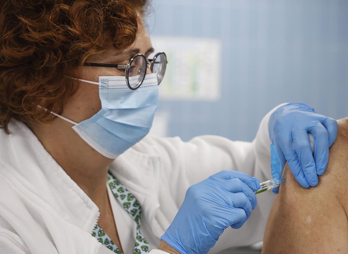 Una enfermera vacuna frente a la gripe y la covid-19.