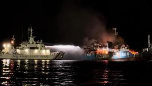 La Guardia Costera de Filipinas frente a un barco incendiado en las costas de Basilán.
