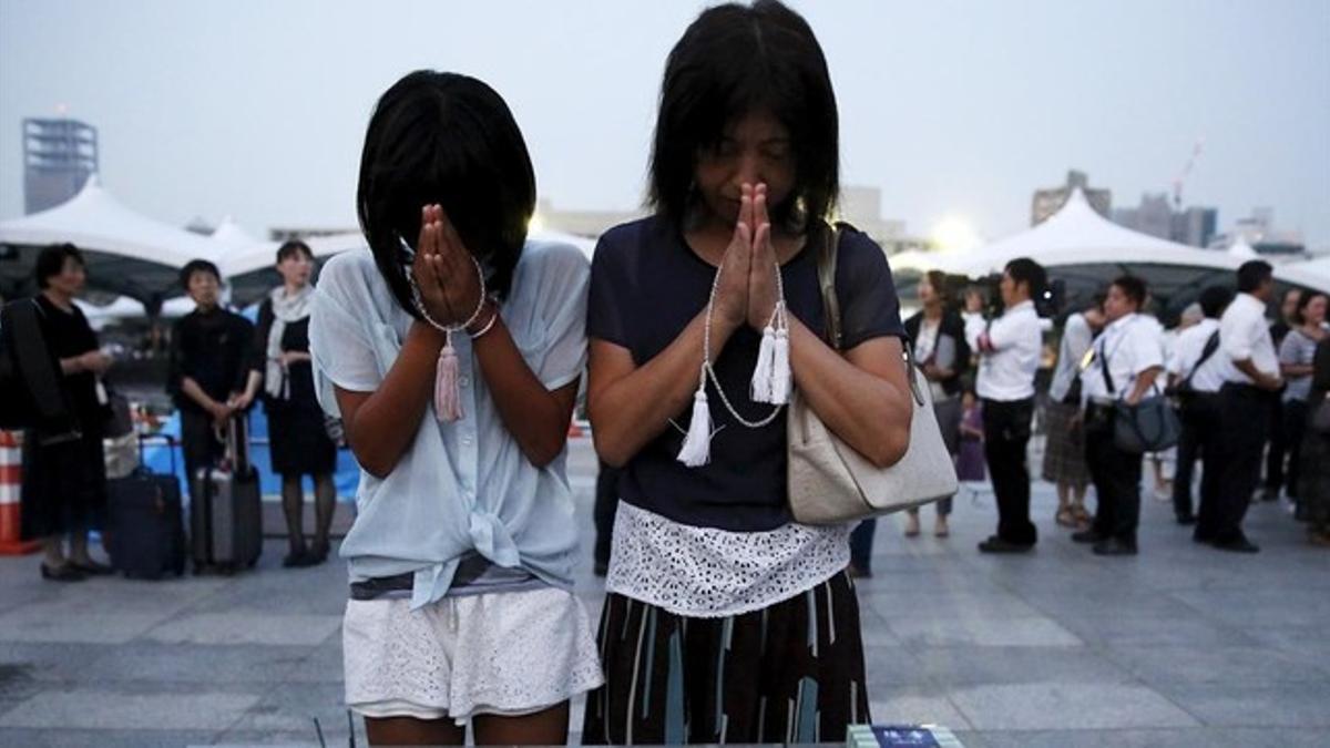 Una madre y una hija oran en el Parque Memorial de la Paz.