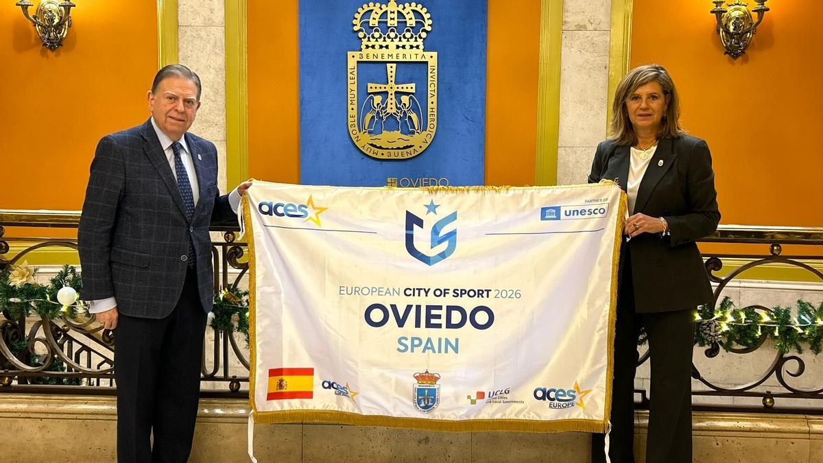 La concejala de Deportes, Concepción Méndez, entrega al alcalde de Oviedo, Alfredo Canteli, la distinción de Ciudad Europea del Deporte recogida en el Parlamento Europeo