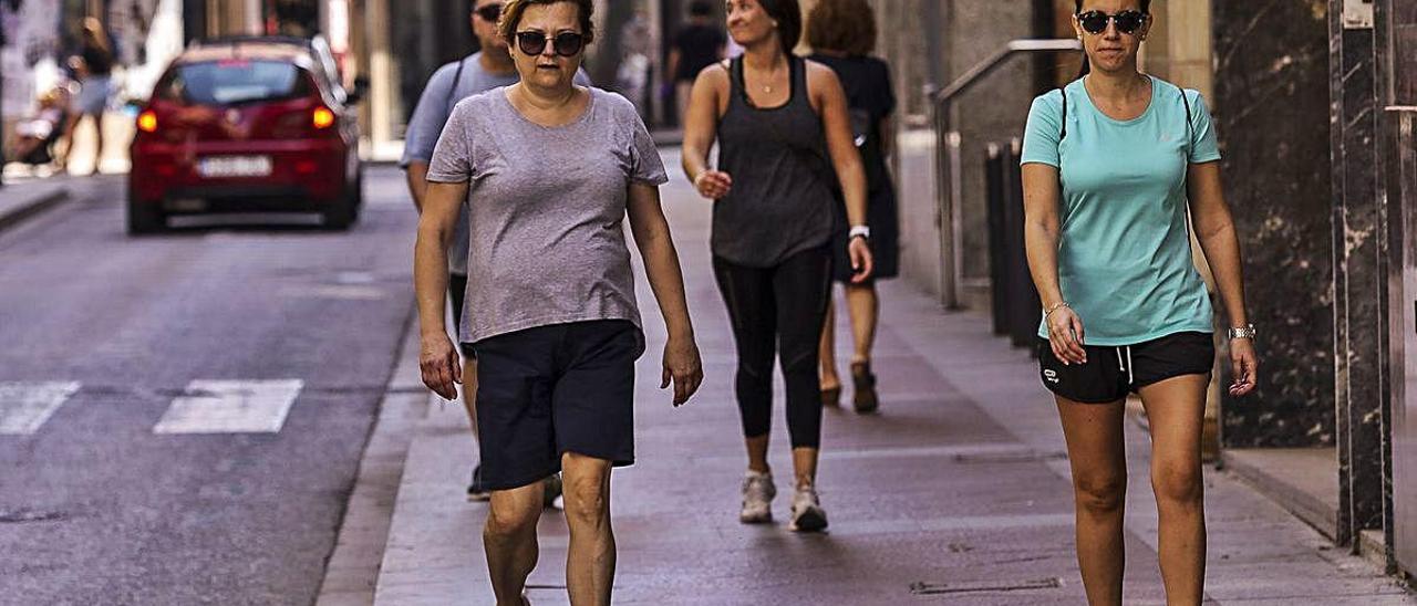 Varias personas caminando por la Corredora, en Elche, sin mascarilla.