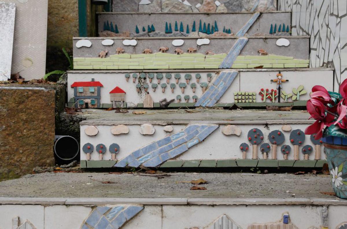 Arriba, las escaleras de su patio decoradas. Sobre estas líneas, Juan Guerra con algunas piezas artísticas en su taller. | M. V.