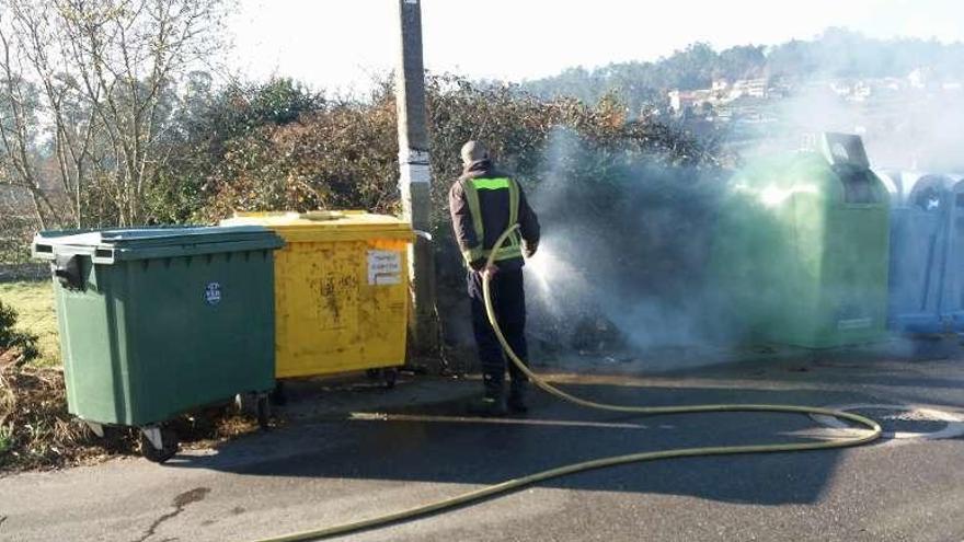 Efectivos del servicio municipal de emergencia extinguiendo uno de los incendios en contenedores, en Mos. // D. P.