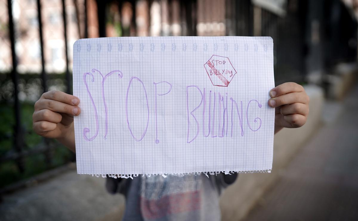 Un niño con un cartel de stop bullying.