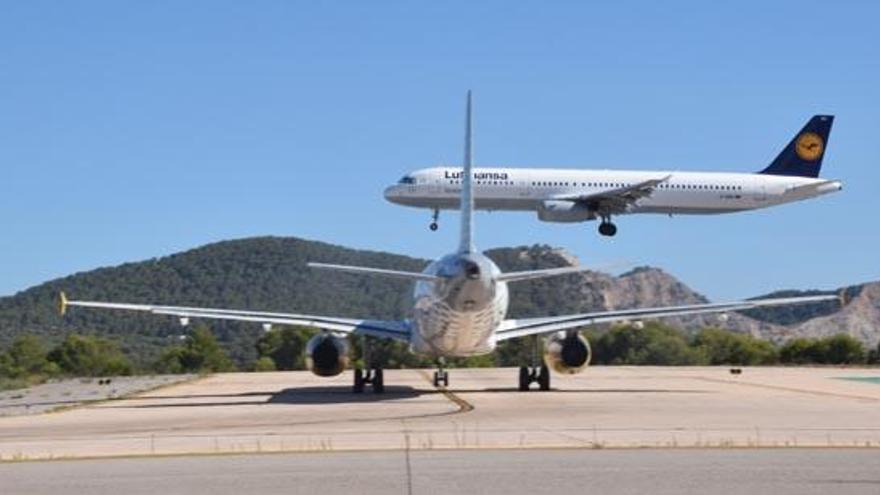 Un avión se dispone a aterrizar mientras otro espera en la cabecera de la pista en la zona más próxima a es Codolar.