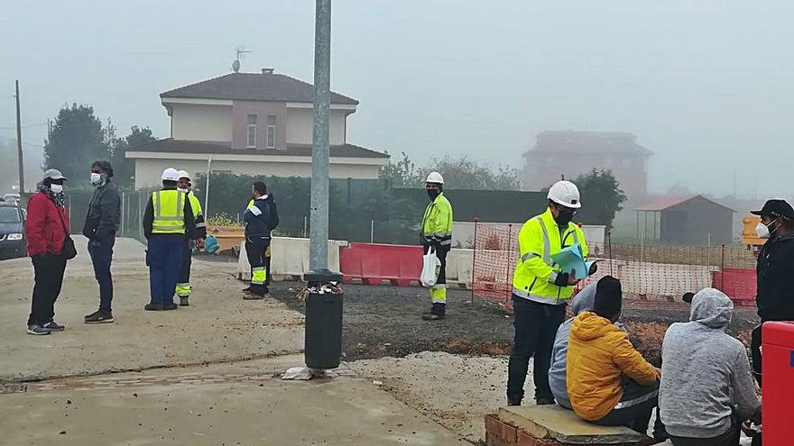 Cuadrillas de obreros, ayer, a las 9 de la mañana, esperando la asignación de trabajo, en uno de los puntos de acceso a la parcela. | P. T.