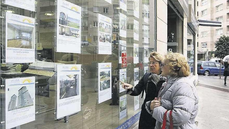 Dos mujeres observan anuncios de una inmobiliaria.