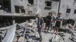 Varios palestinos entre los escombros de un edificio en la frontera de Gaza.