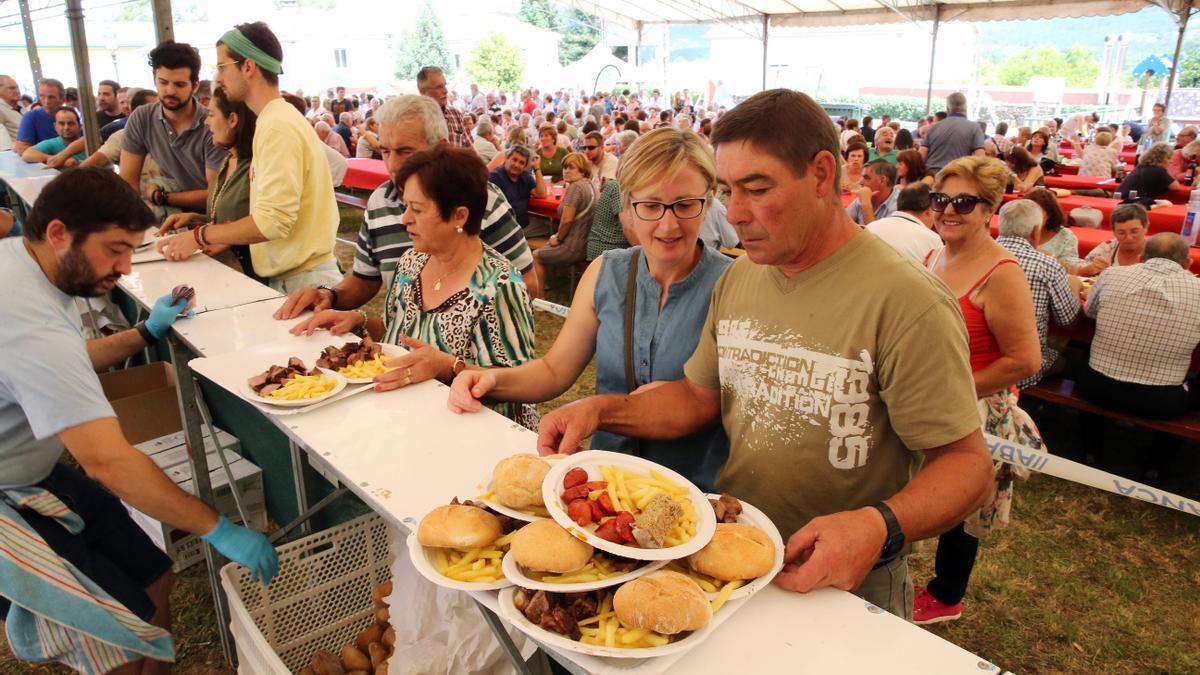 Unas personas compran raciones de &quot;chanfaina&quot; y ternera en la última edición de la fiesta de Fornelos.