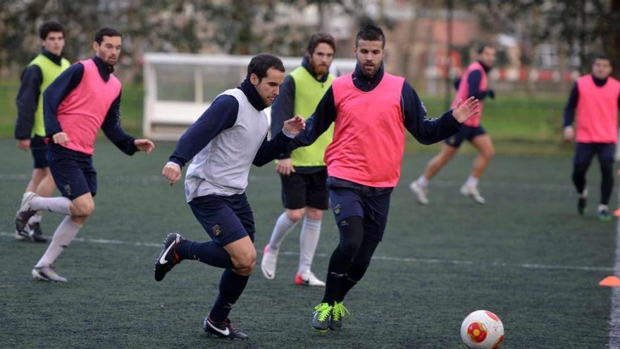 Moreira trata de llevarse el balón ante la presencia de Feito en un entrenamiento. // Gustavo Santos