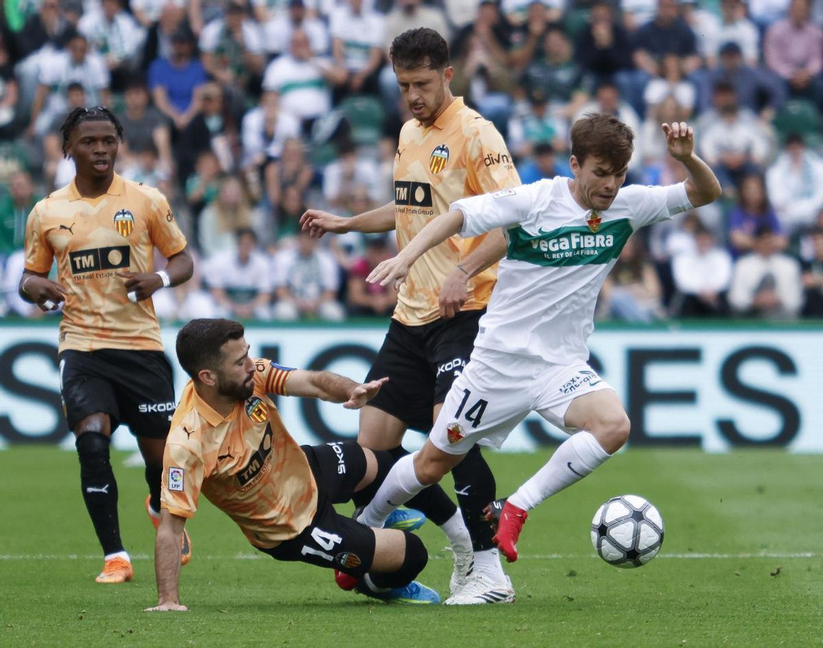 Gayà intenta frenar a Aleix Febas durante el partido del sábado en el Martínez Valero.  | PABLO MIRANZO / EFE